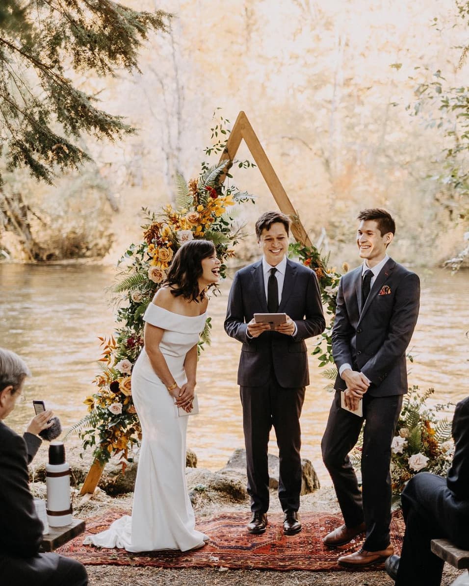 boho wedding ceremony on a creek with an off-the-shoulder wedding dress