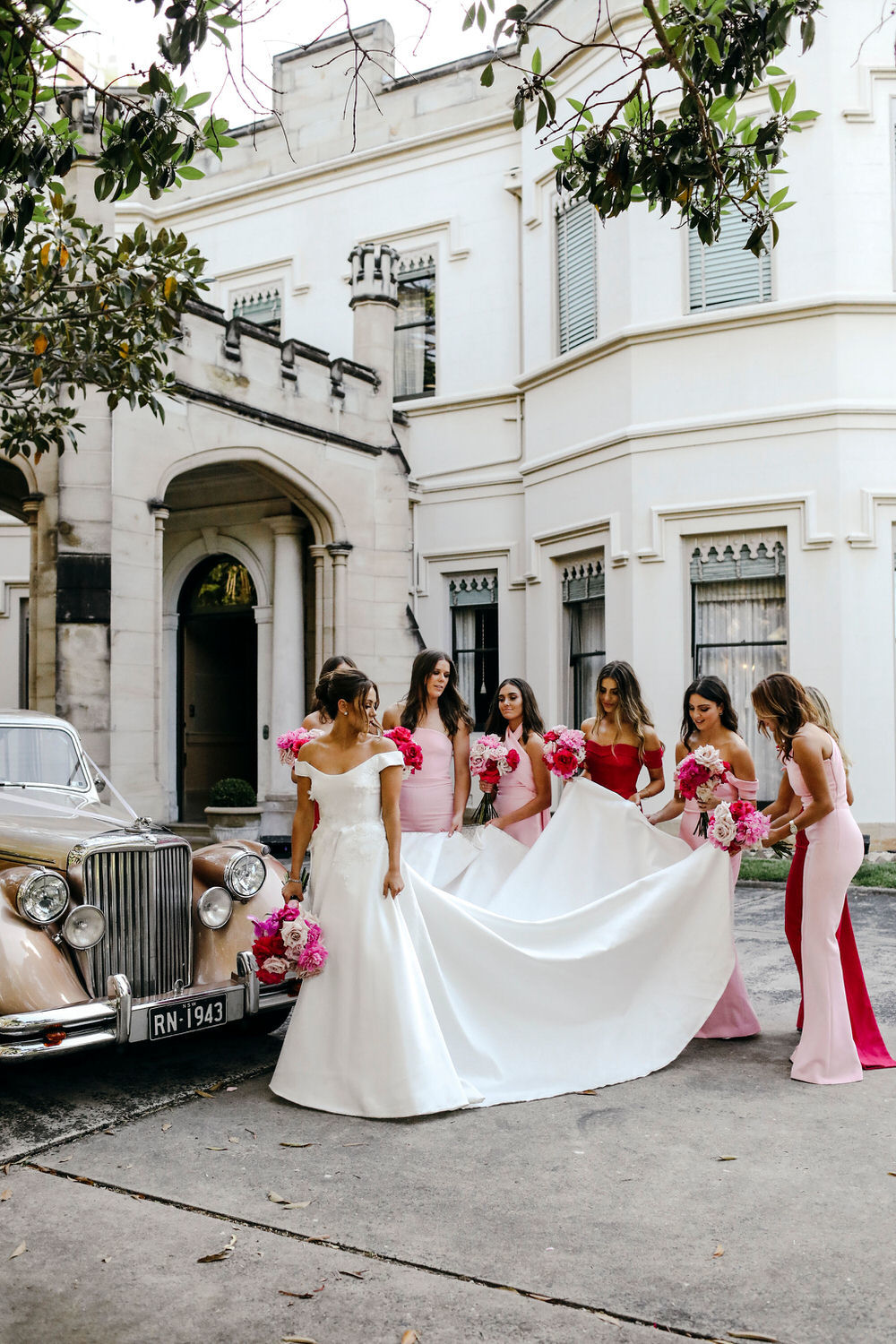 bridesmaids helping the bride with her dress